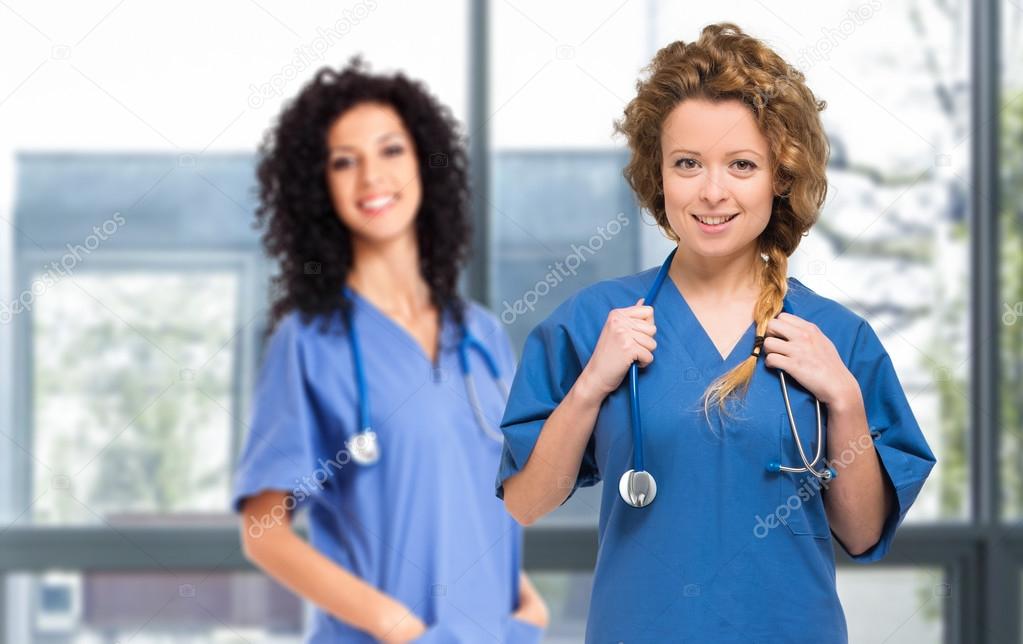 nurses with stethoscopes looking at camera 
