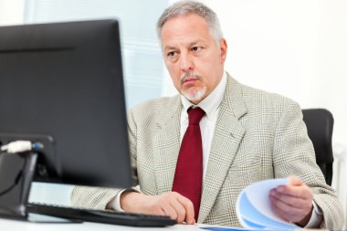 Bilgisayarda çalışan üst düzey iş adamı