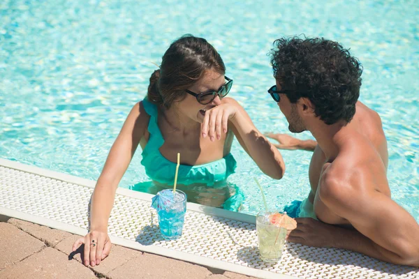 Pareja celebración de cócteles en la piscina —  Fotos de Stock