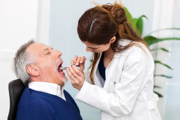 Doctor checking patient's inflamed throat — Stock Photo, Image