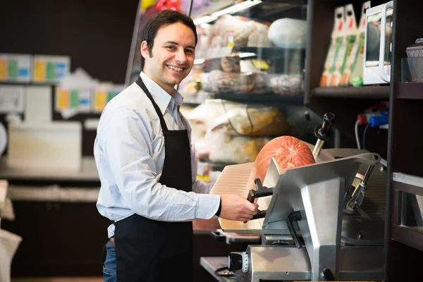 Lojista cortando carne fatiada italiana — Fotografia de Stock