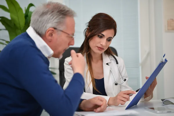 Läkaren talar till hennes patient — Stockfoto