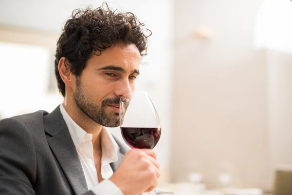 Man smelling red wine