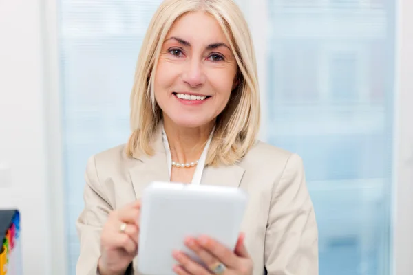 Volwassen zakenvrouw met behulp van een tablet — Stockfoto