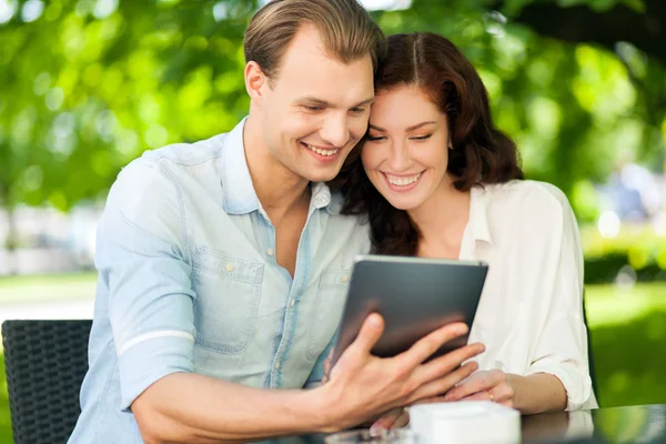 Lachende paar met behulp van een tablet Rechtenvrije Stockafbeeldingen