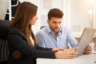 Dizüstü bilgisayar kullanarak gülümseyen iş adamları