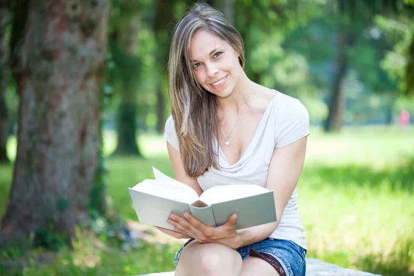 Woman sitting on bench in a park — Stock Photo, Image