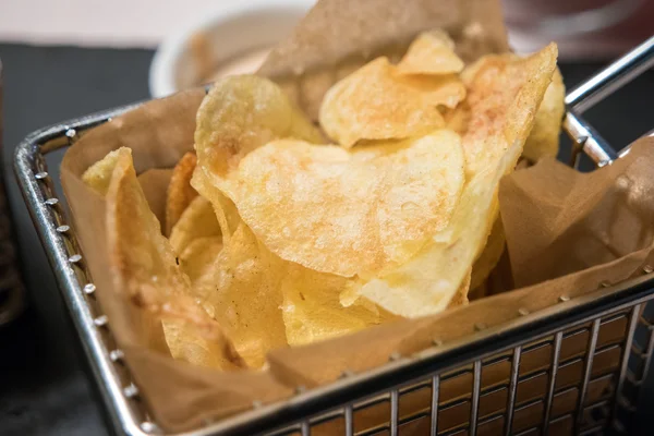 Fried chips served in a fryer basket — Stock Photo, Image