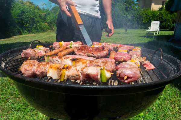 Hombre preparando carne en parrilla barbacoa — Foto de Stock