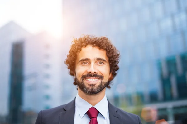 Smiling businessman in urban scene — Stock Photo, Image