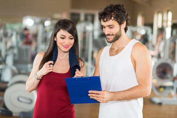 Trainer een oefening uitleggen aan een vrouw — Stockfoto