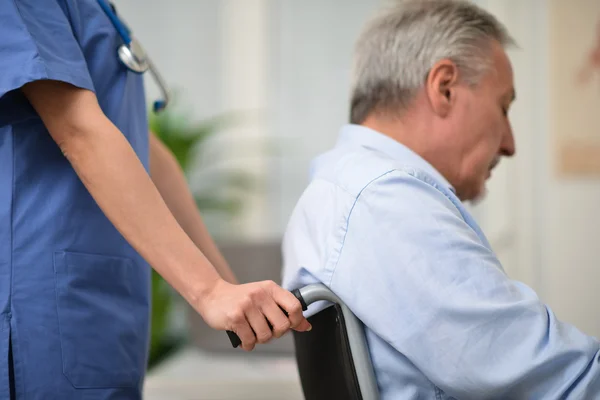 Enfermera empujando a un paciente herido — Foto de Stock