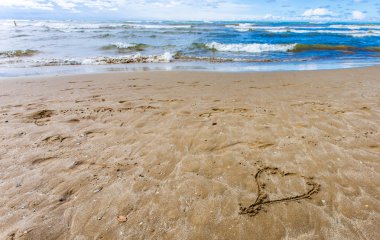 Sahilde çizilmiş kalp simgesi