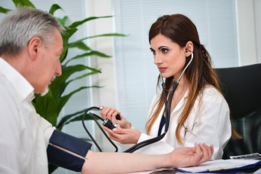 Doktor kan basıncını ölçüyor.