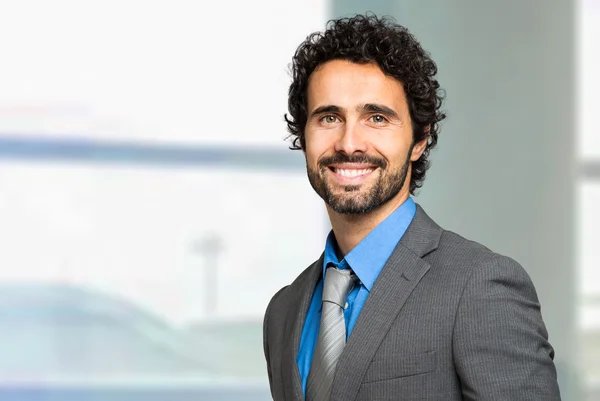 Businessman looking at camera near window — Stock Photo, Image