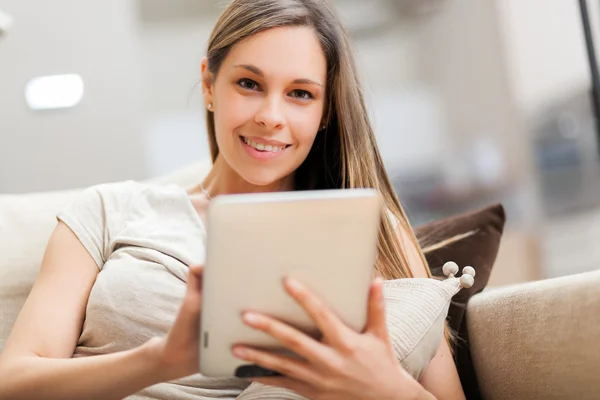 Женщина, использующая планшетный компьютер в своей квартире — стоковое фото