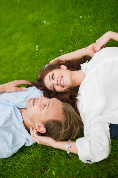 Feliz casal deitado na grama — Fotografia de Stock