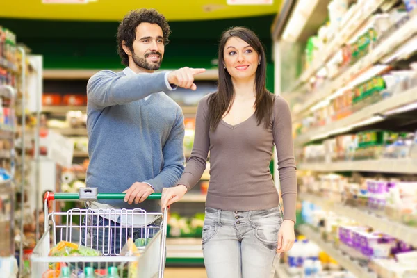 Casal jovem compras em um supermercado — Fotografia de Stock