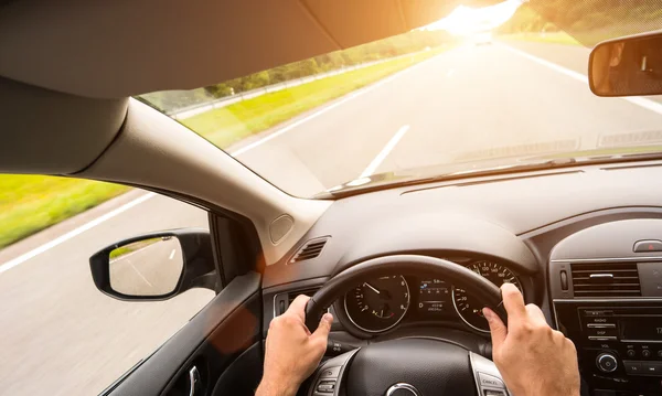 Hombre conduciendo su coche al atardecer —  Fotos de Stock