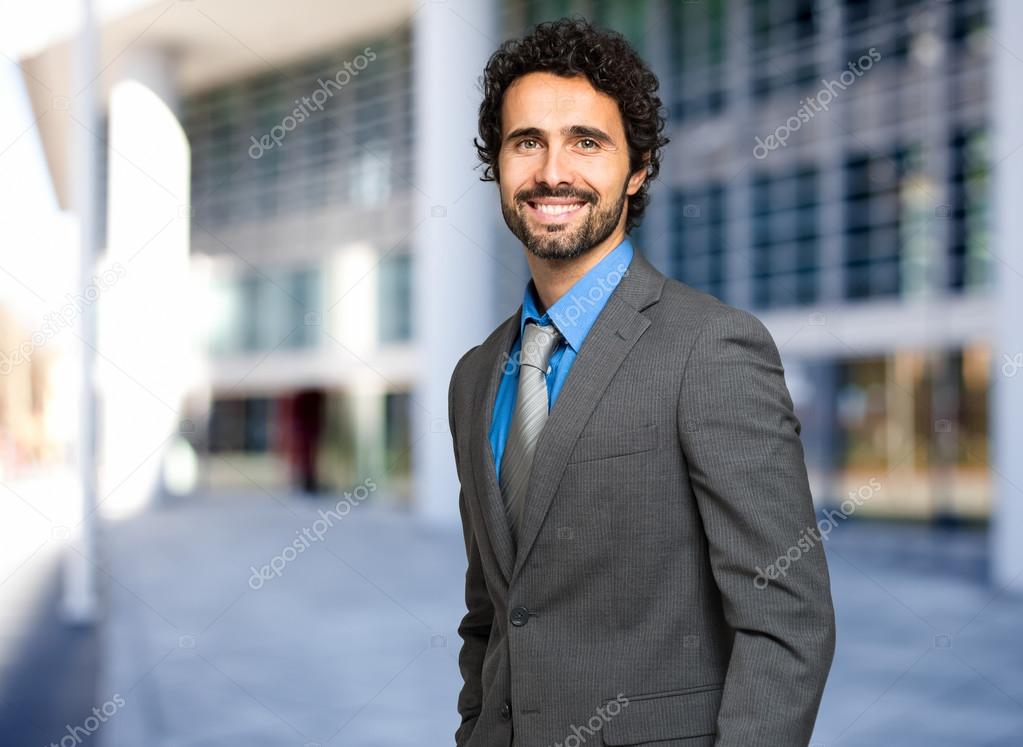 businessman looking at camera in front of  building 