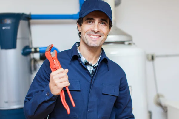 Encanador reparando um aquecedor de água quente — Fotografia de Stock