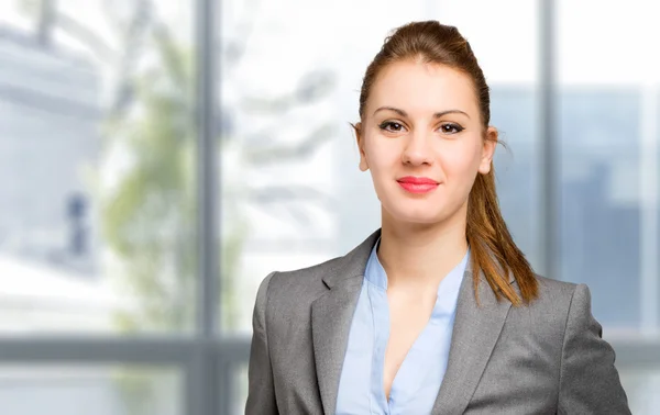 Geschäftsfrau blickt im Büro in die Kamera — Stockfoto