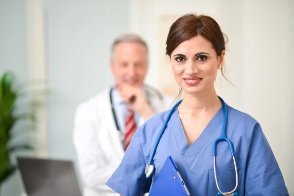 Pielęgniarka z folderu przed kolega — Zdjęcie stockowe