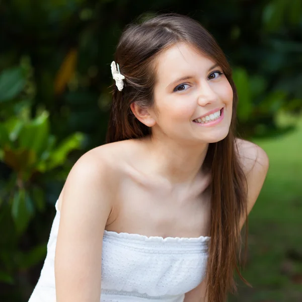 Młoda kobieta uśmiechając się w parku — Zdjęcie stockowe