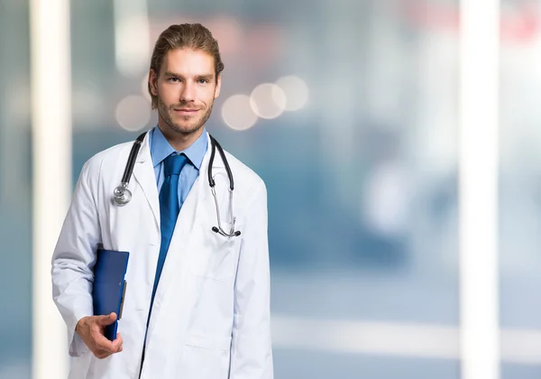 Knappe dokter op heldere onscherpe achtergrond — Stockfoto