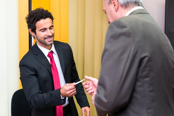 Businessman giving card to customer — Stock Photo, Image