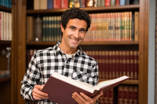 Hombre sonriente leyendo un libro — Foto de Stock