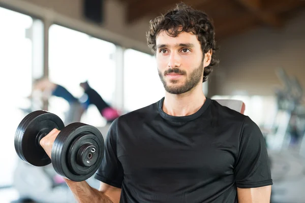 Bodybuilder using dumbbell to work out — Stock Photo, Image