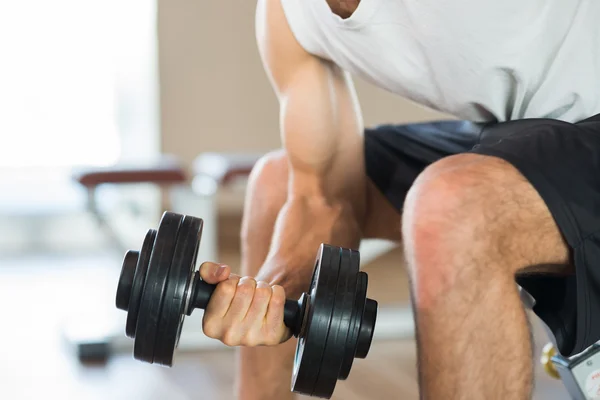 Bodybuilder using dumbbell to work out — Stock Photo, Image