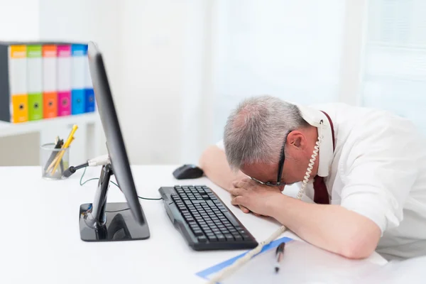 Triest zakenman liggen gezicht op Bureau — Stockfoto