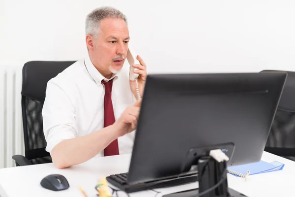 Empresário trabalhando em seu escritório — Fotografia de Stock