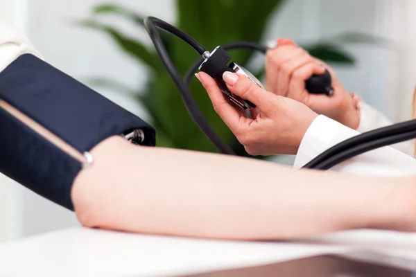 Médico revisando la presión arterial del paciente — Foto de Stock