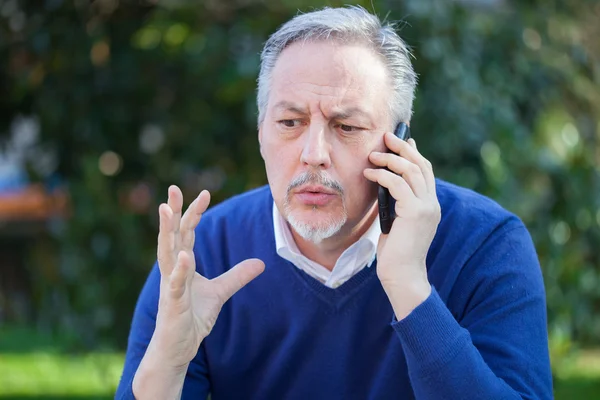 Άνθρωπος που μιλάει στο τηλέφωνο στο πάρκο — Φωτογραφία Αρχείου
