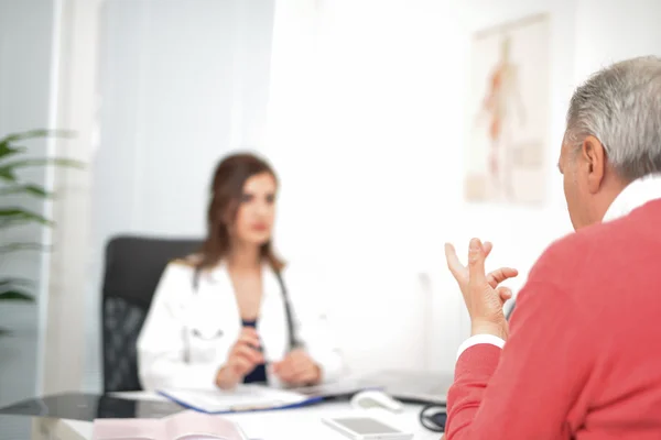 Läkaren talar till hennes patient — Stockfoto