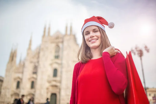 在意大利米兰 身穿红色衣服的年轻女子在圣诞购物 面带微笑 — 图库照片