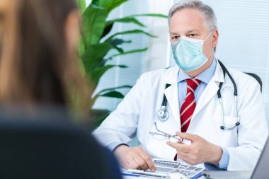 Doktor hastasıyla konuşuyor, CVid Coronavirus konsepti.