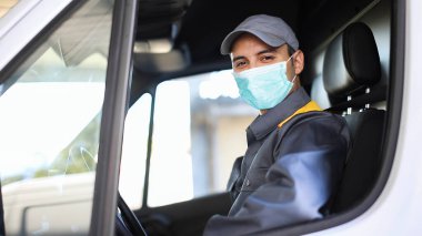 Minibüs süren gülümseyen bir kurye, covid coronavirus konsepti