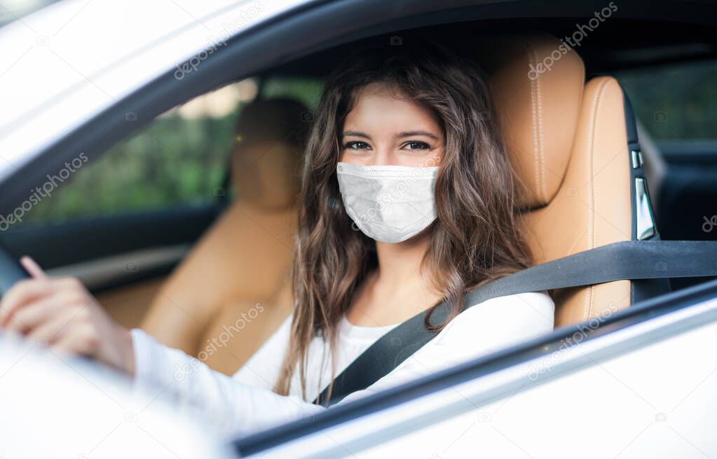 Woman driving car while wearing a mask, coronavirus covid concept