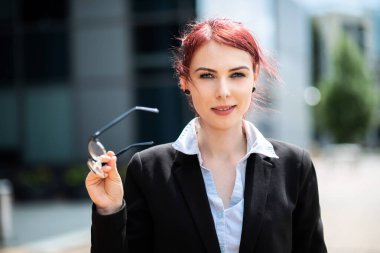 Modern bir şehir ortamında kendine güvenen genç bir bayan yönetici.