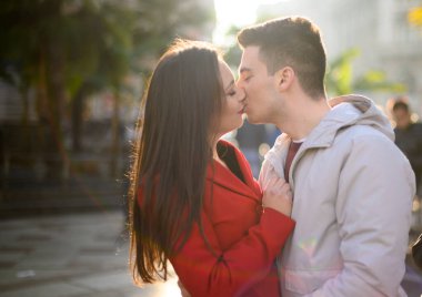 Genç çift dışarıda tutkuyla öpüşüyor.