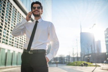 Cep telefonuyla konuşan yakışıklı bir işadamı, doğal lens fişeği.