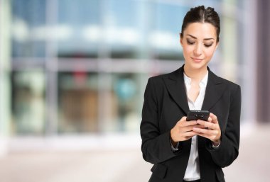 İş kadını cep telefonunu kullanıyor.