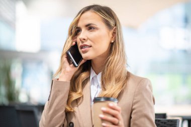 Kendine güvenen genç bayan yönetici dışarıdaki saatini kontrol ediyor.