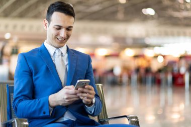 Havaalanındaki telefonu kullanan bir iş adamı.