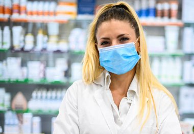 Eczanede çalışan koruyucu maskeli bir kadın eczacı. Tıbbi sağlık hizmeti kavramı.