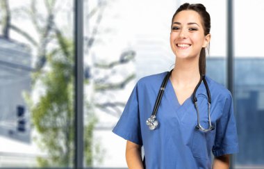 Parlak bir klinikte gülümseyen hemşire portresi.